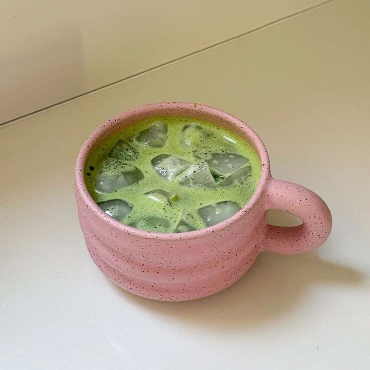 Iced matcha latte glacé au dégradé vert sur blanc dans un grand verre